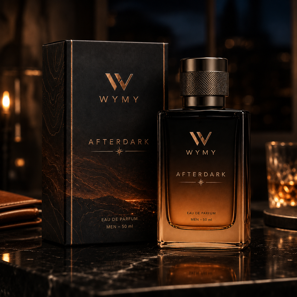 A bottle of WMY Afterdark Eau de Parfum with a matching black and gold box, displayed on a dark marble surface with warm candlelight in the background.